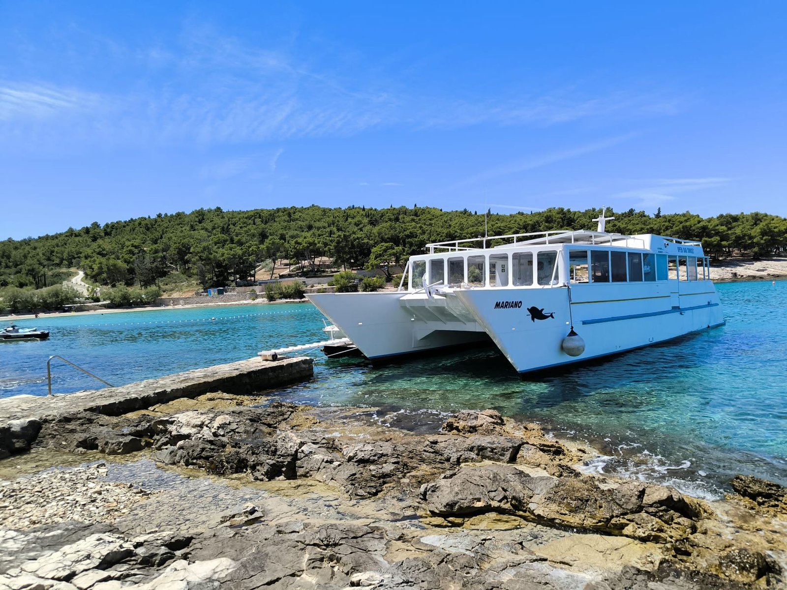 Crystal clear shallow water in a Čiovo bay with a small boat moored
