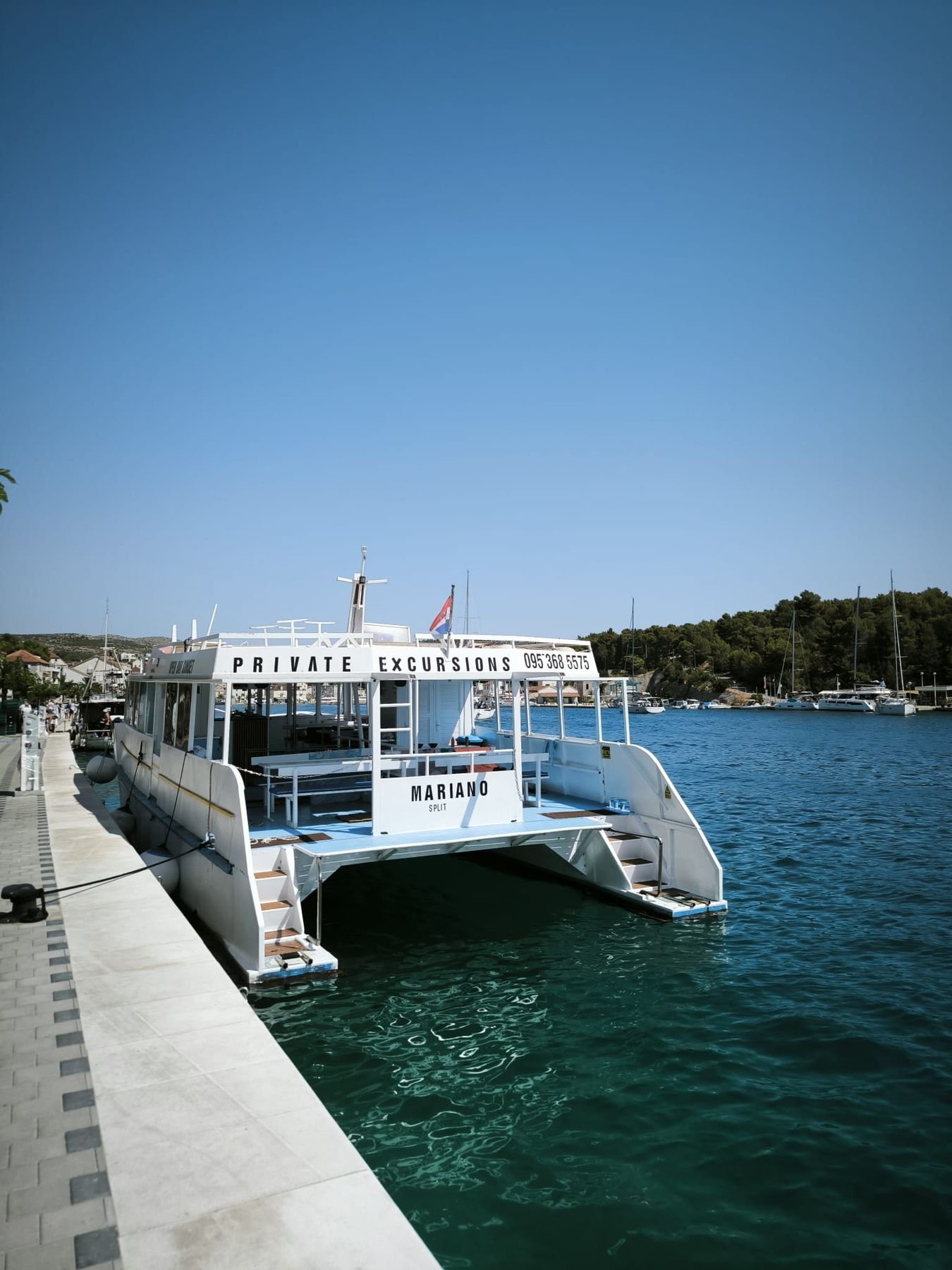 Mariano moored along a palm-lined promenade